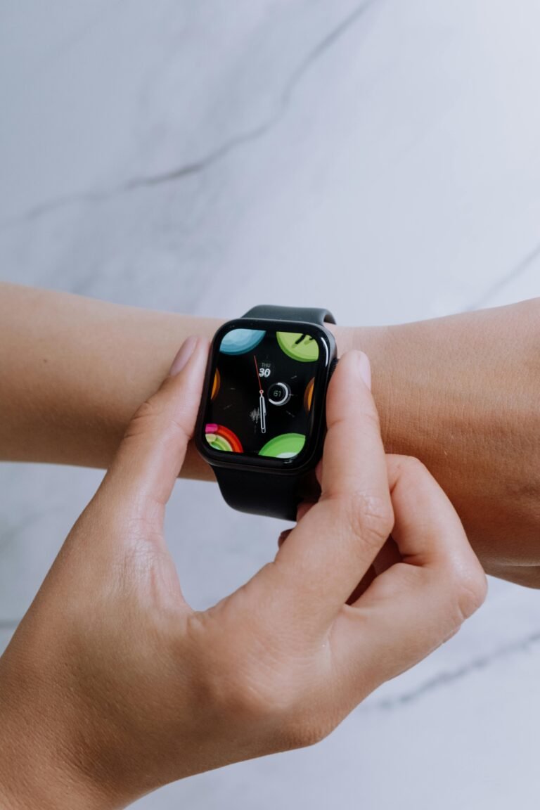 Modern smartwatch displayed on wrist with a decorative marble background, showcasing vibrant touchscreen and technology.